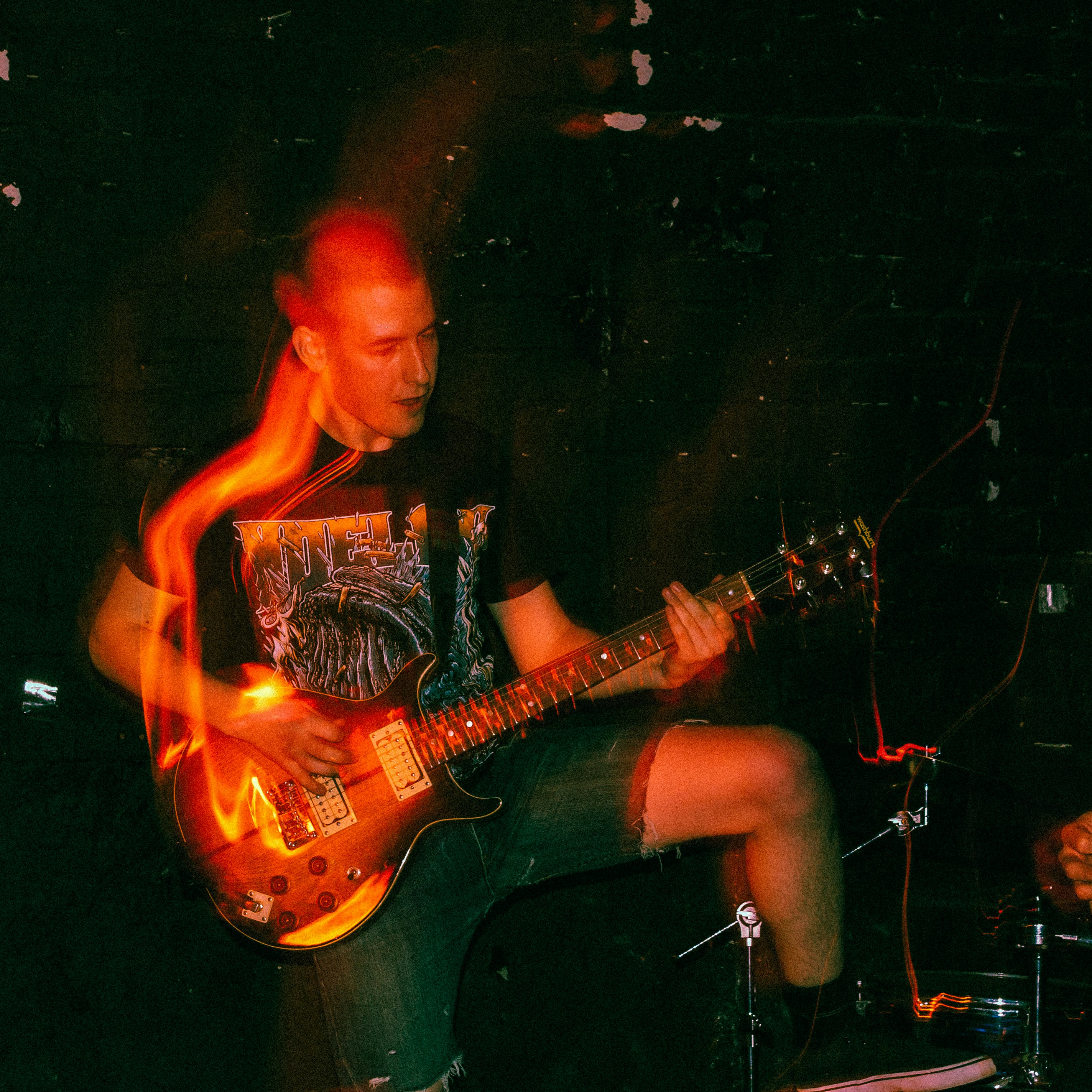 man in black shirt playing electric guitar